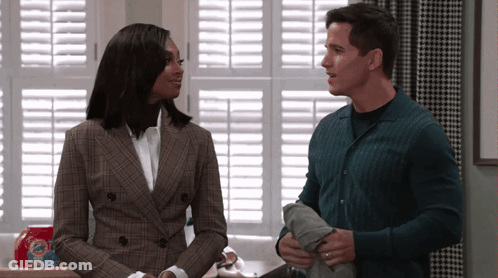 Man And Woman Standing In Front Of Window With Shutters And Tide Laundry Detergent GIF