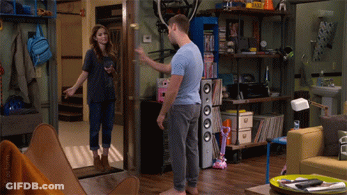 Man And Woman Standing In Living Room With Taxi Sign GIF