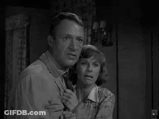 Man And Woman Standing In Room Looking At Something GIF
