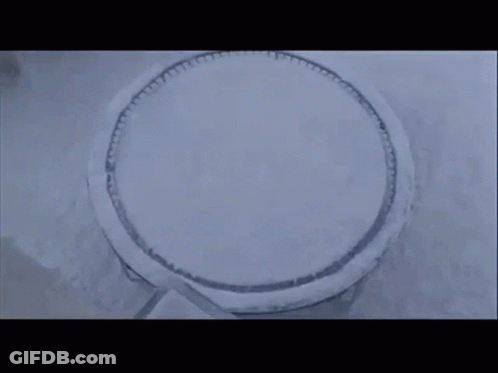 Man And Woman Standing In Snow In Front Of House GIF