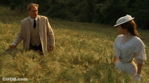 Man And Woman Standing In Tall Grass GIF