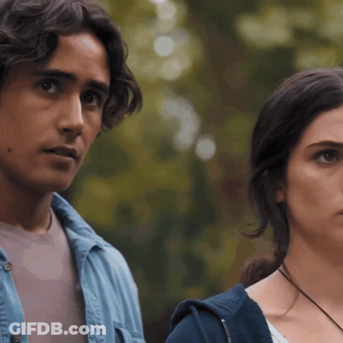 Man And Woman Standing Looking At Camera GIF
