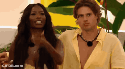 Man And Woman Standing Near Yellow Wall GIF