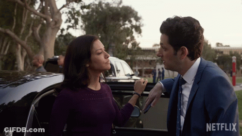 Man And Woman Standing Next To Car With Netflix Logo GIF