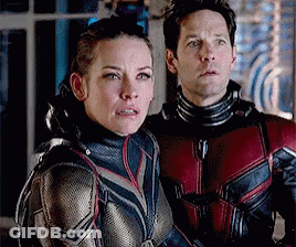 Man And Woman Standing Next To Each Other Looking At Camera GIF
