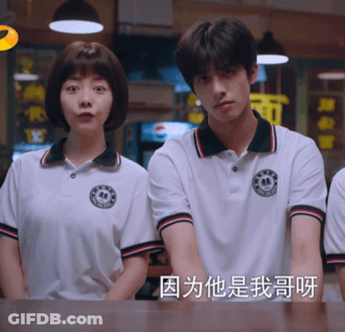 Man And Woman Standing Next To Each Other With Chinese Writing GIF