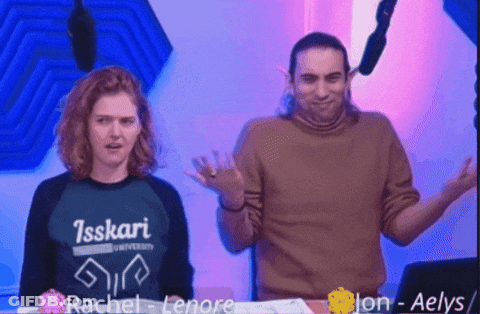 Man And Woman Standing Next To Each Other With Isskari University Shirt GIF