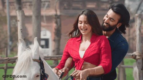Man And Woman Standing Next To Horse GIF