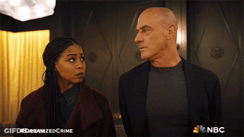 Man And Woman Standing Next To NBC Logo GIF