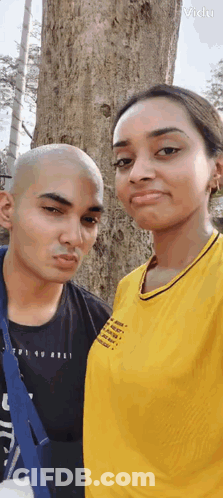 Man And Woman Standing Next To Tree GIF