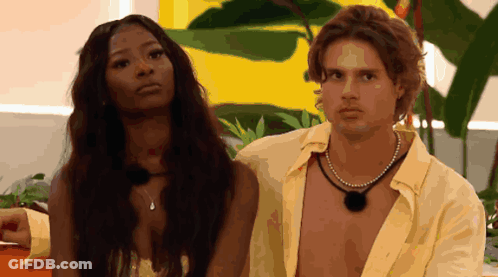 Man And Woman Standing Next To Yellow Wall GIF