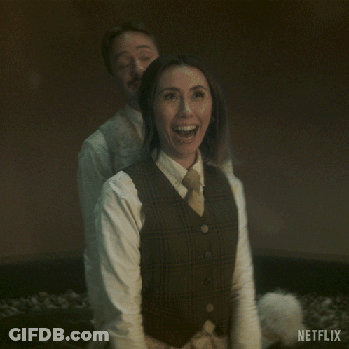 Man And Woman Standing With Netflix Logo GIF