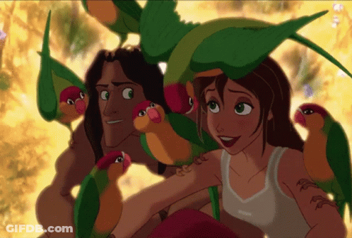 Man And Woman Surrounded By Colorful Parrots GIF
