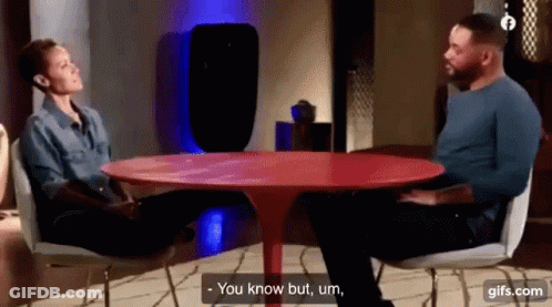 Man And Woman Talking At Red Table GIF
