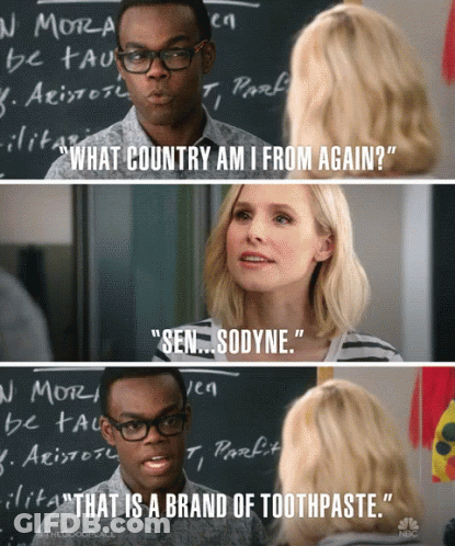 Man And Woman Talking In Front Of Blackboard Saying What Country Am I From Again GIF