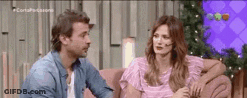 Man And Woman Talking On Pink Couch GIF