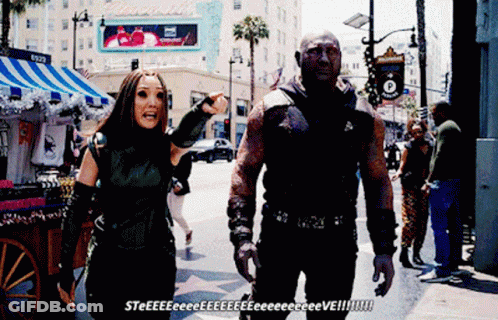 Man And Woman Walking By Hollywood Sign GIF