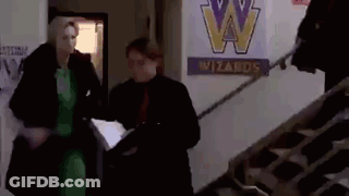Man And Woman Walking Down Stairs Past Wizards Sign GIF