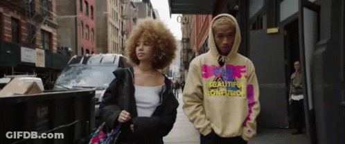 Man And Woman Walking Down Street Wearing Hoodie Saying Reality GIF