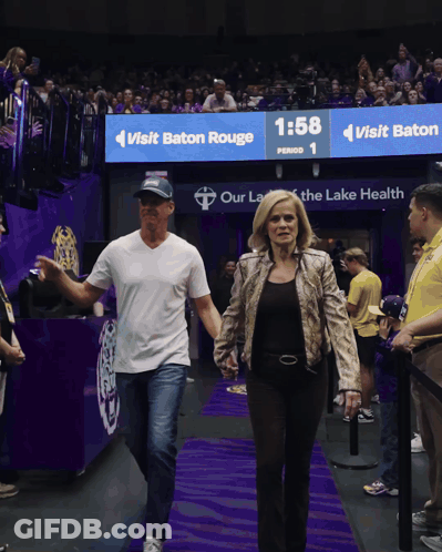 Man And Woman Walking In Front Of Baton Rouge Sign GIF