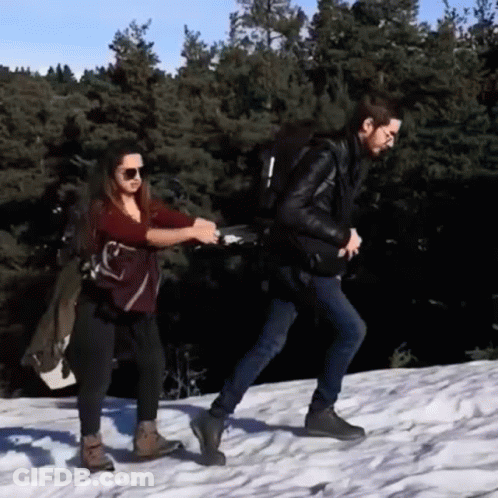 Man And Woman Walking In Snow Holding Hands GIF