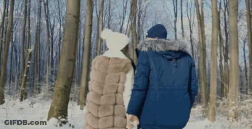 Man And Woman Walking Through Snow GIF