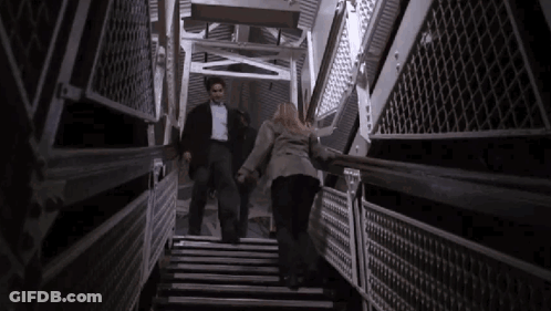 Man And Woman Walking Up Stairs Holding Hands GIF