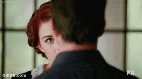 Man And Woman With Red And Green Hair Looking At Each Other GIF