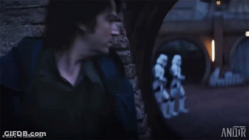 Man At Brick Wall With Stormtroopers Walking GIF