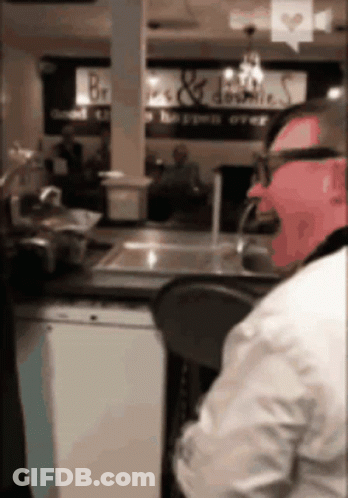 Man At Counter With Bread & Donuts Sign GIF