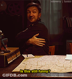 Man At Desk With Arms Crossed Says Is This Still Funny GIF