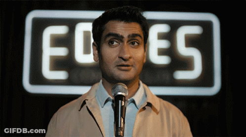 Man At Microphone In Front Of Ed Es Sign GIF