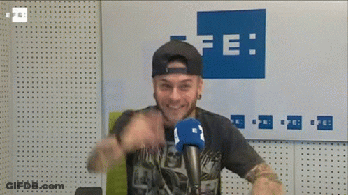 Man At Microphone In Front Of Wall Saying Fe GIF