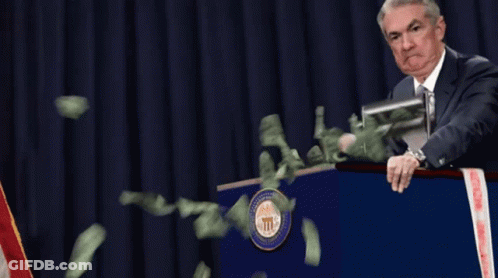 Man At Podium With Money Flying Out GIF