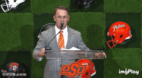 Man At Podium With Pokea Helmet GIF