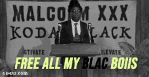 Man At Podium With Sign Saying Malcolm XXX Kodak Black GIF