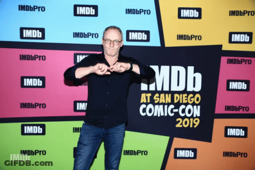 Man At San Diego Comic Con With IMDb Wall GIF