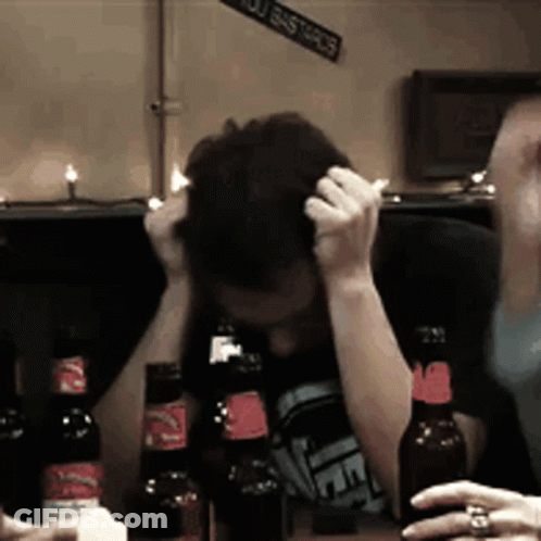 Man At Table With Beer And You Bastards Sign GIF