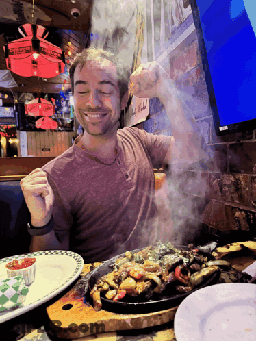 Man At Table With Food And Chuck E Cheese Sign GIF