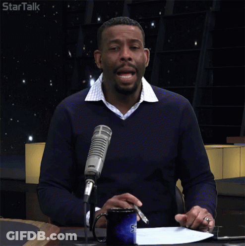 Man At Table With Microphone And Startalk Logo GIF