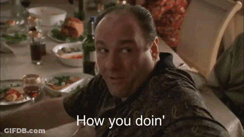 Man At Table With Wine Bottle And Plates Of Food GIF