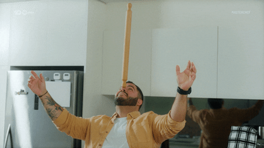 Man Balance Rolling Pin On His Nose GIF