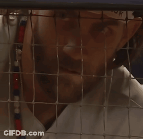 Man Behind Fence Looking At Camera GIF