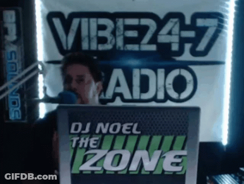 Man Behind Microphone In Front Of DJ Noel The Zone Sign GIF