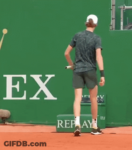 Man Bending Over To Pick Up Tennis Racket GIF