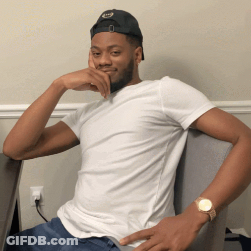 Man Black Hat White Shirt Sitting In Chair GIF