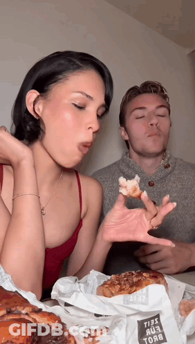 Man Blowing Kiss To Woman Eating Donuts GIF