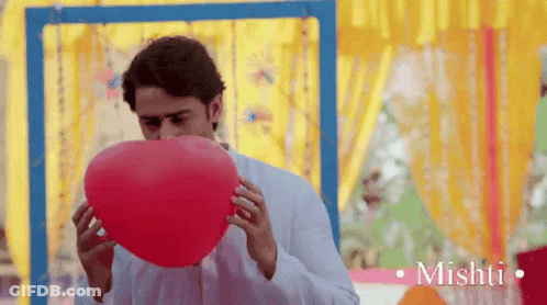 Man Blowing Up Red Balloon With Mishti GIF