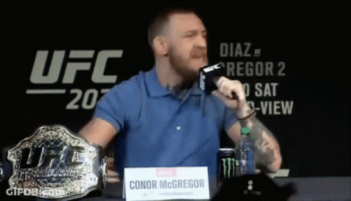 Man Blue Shirt Holding Microphone And UFC Belt GIF