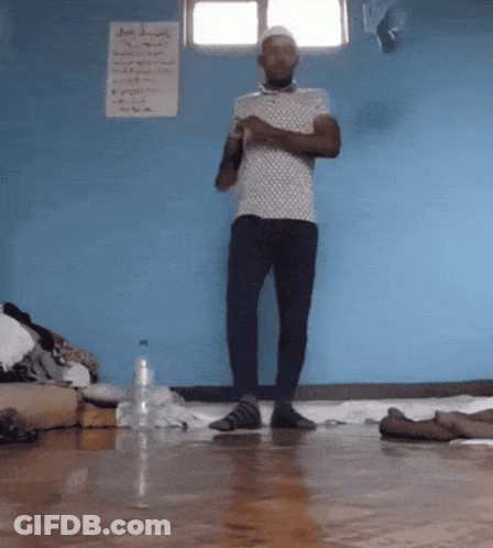 Man By Blue Wall With A Sign GIF